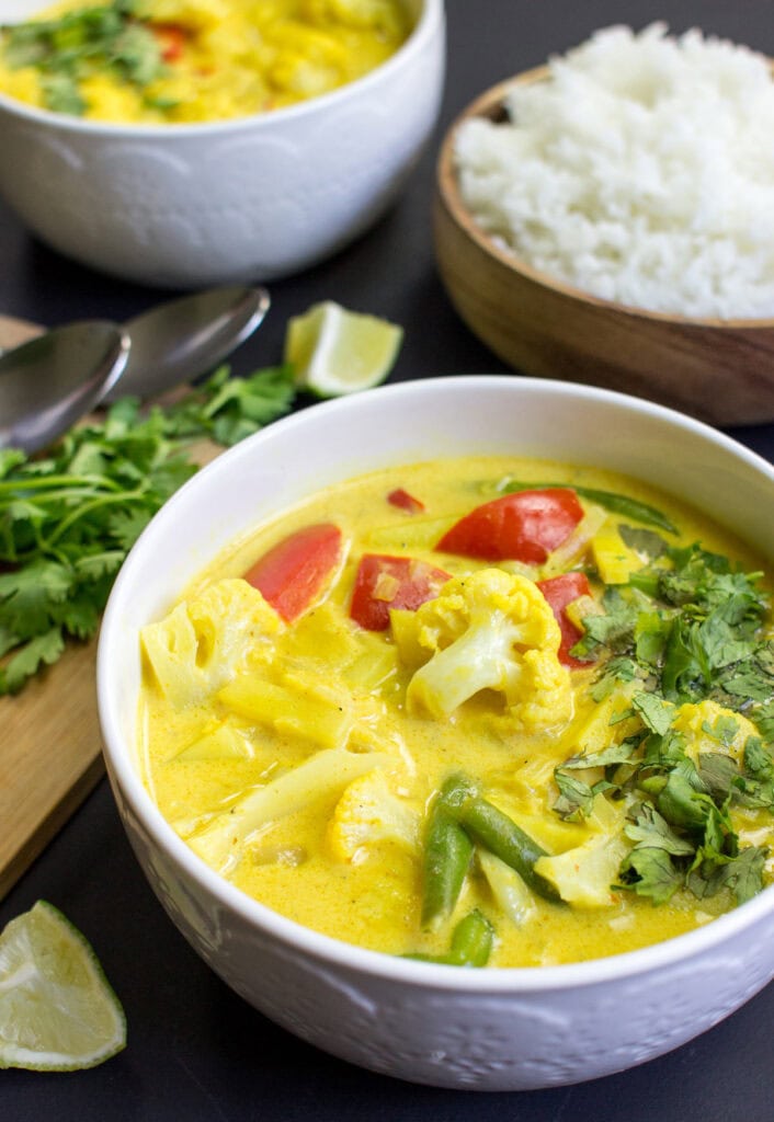 Cauliflower Curry is in the bowl with parsley and lemon wedge on the side | Hurry The Food Up