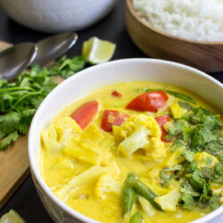Cauliflower Curry is in the bowl with parsley and lemon wedge on the side | Hurry The Food Up