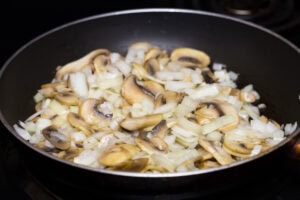 Chopped ingredients like mushrooms, onions. garlic are frying on the pan | Hurry The Food Up