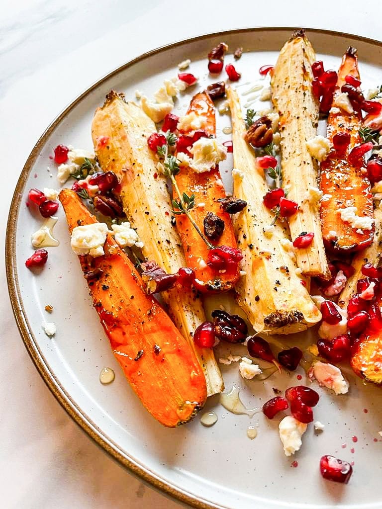 Honey Roasted Carrots & Parsnips are served on the plate on the white table #carrots #honey | 