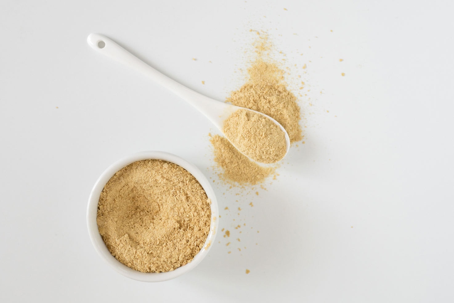 Nutritional yeast in the small bowl with white spoon | Hurry The Food Up