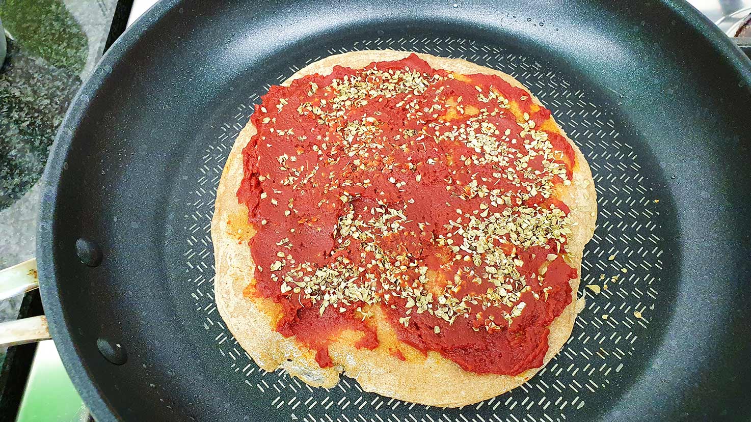 Tomato sauce and dried herbs are layered over the base #flour #olive oil | 