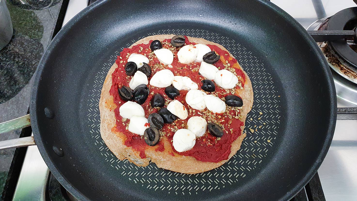 The mozzarella and olives are laid over the top of the base #tomato paste #dried Italian herbs | 
