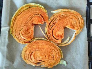Marinated cabbage steaks are on a sheet pan before they go into the oven | Hurry The Food Up
