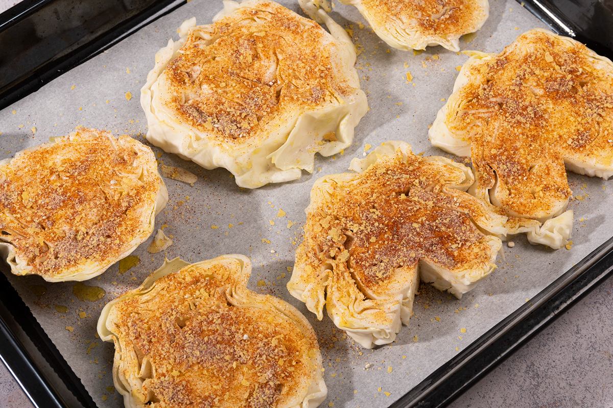 Seasoned cabbage steaks on a sheet pan ready to go in the oven | Hurry The Food Up