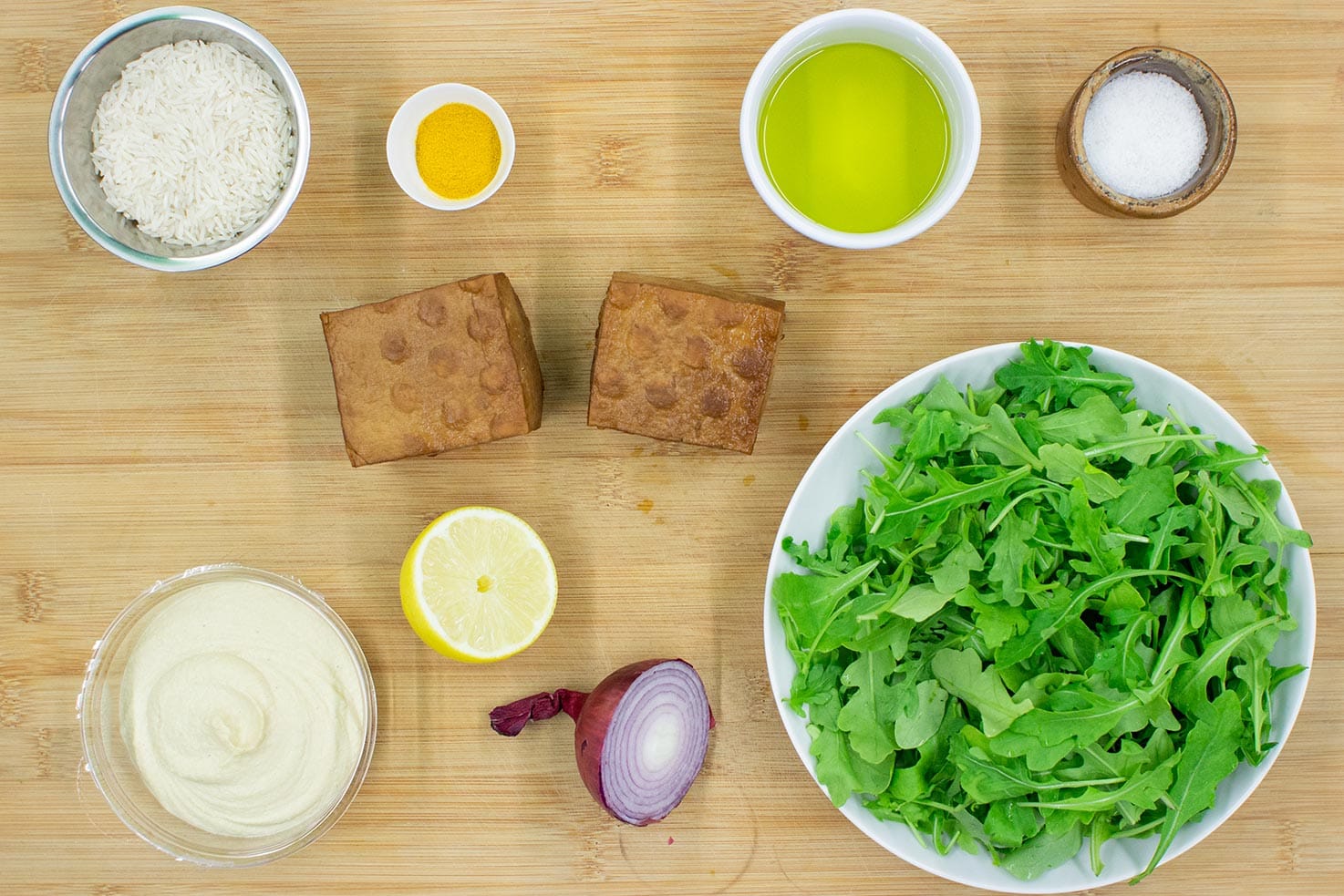 The meal ingredients are on the chopping board - rice, tofu, lamb’s lettuce, turmeric, hummus, onion #lemon juice #salt | 