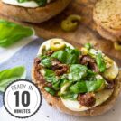 An open faced sandwich of basil, sundried tomatoes & mozarella with a time badge in the bottom left corner | Hurry The Food Up