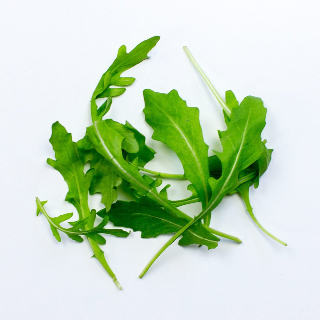 Arugula on white surface