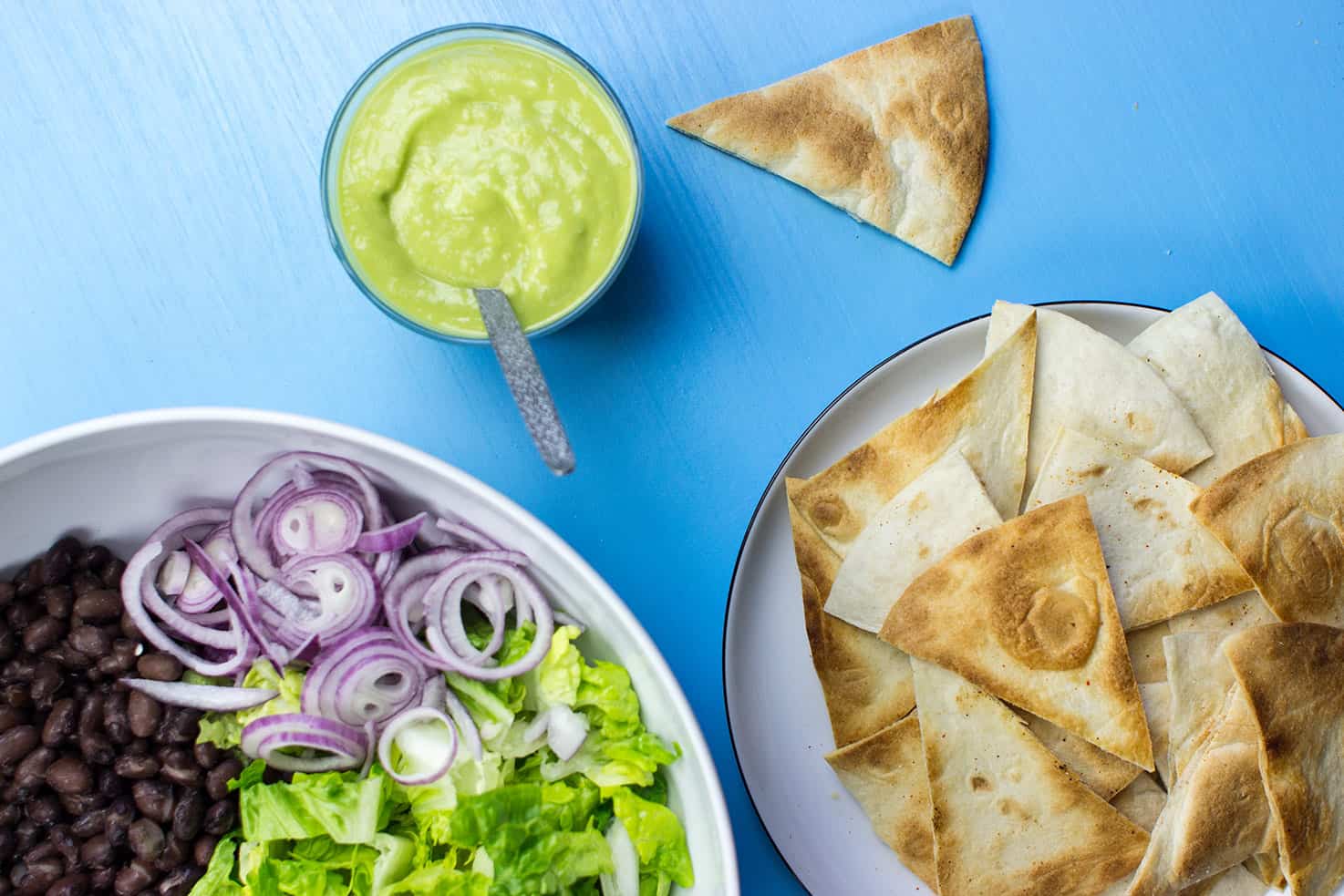Vegan avocado salad dressing in a bowl. The salad and nachos are nearby | Hurry The food Up