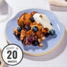 A portion of dessert served on a blue plate with a dollop of greek yogurt with a time stamp in the bottom left hand corner | Hurry The Food Up