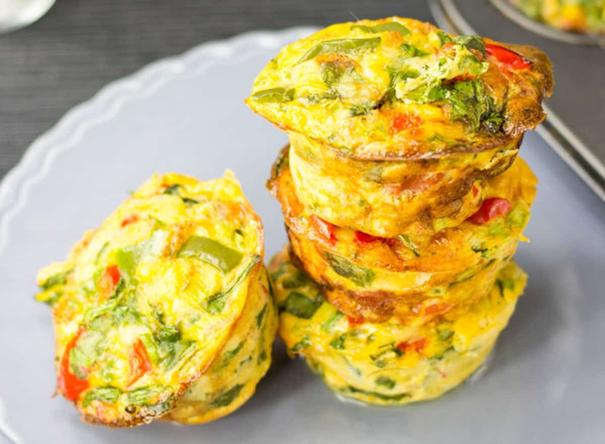 4 breakfast egg muffins, spicy pepper flavour, on a grey plate, three of them are piled on each other. | Hurry The Food Up