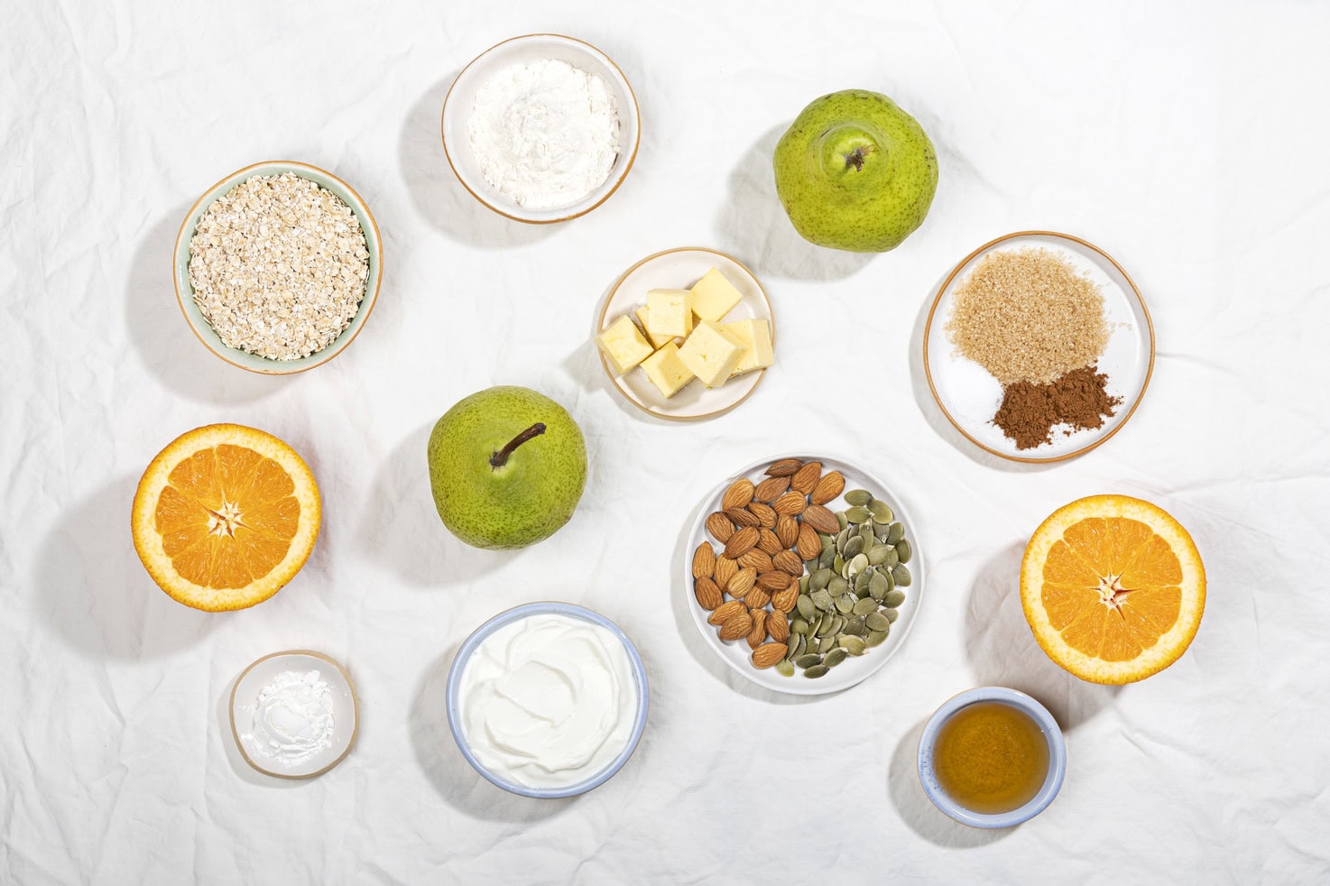 The ingredients for pear crisp are laid out including pears, butter, oats, seeds, orange, cornflour & yoghurt. | Hurry The Food Up