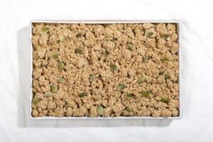 A tray of healthy breakfast pear crisp is laid out on a white surface, before it goes into the oven. | Hurry The Food Up