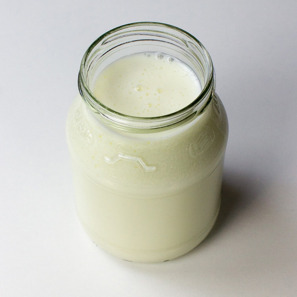 A jar of buttermilk on white background