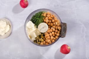 Chickpea salad sandwich ingredients are in the bowl of the food processor | Hurry The Food Up