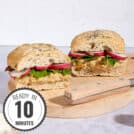 Two chickpea salad sandwiches with knife are on a wooden board with a time stamp in the bottom left hand corner | Hurry The Food Up
