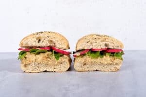 Two chickpea salad sandwiches are on a marble surface next to each other | Hurry The Food Up