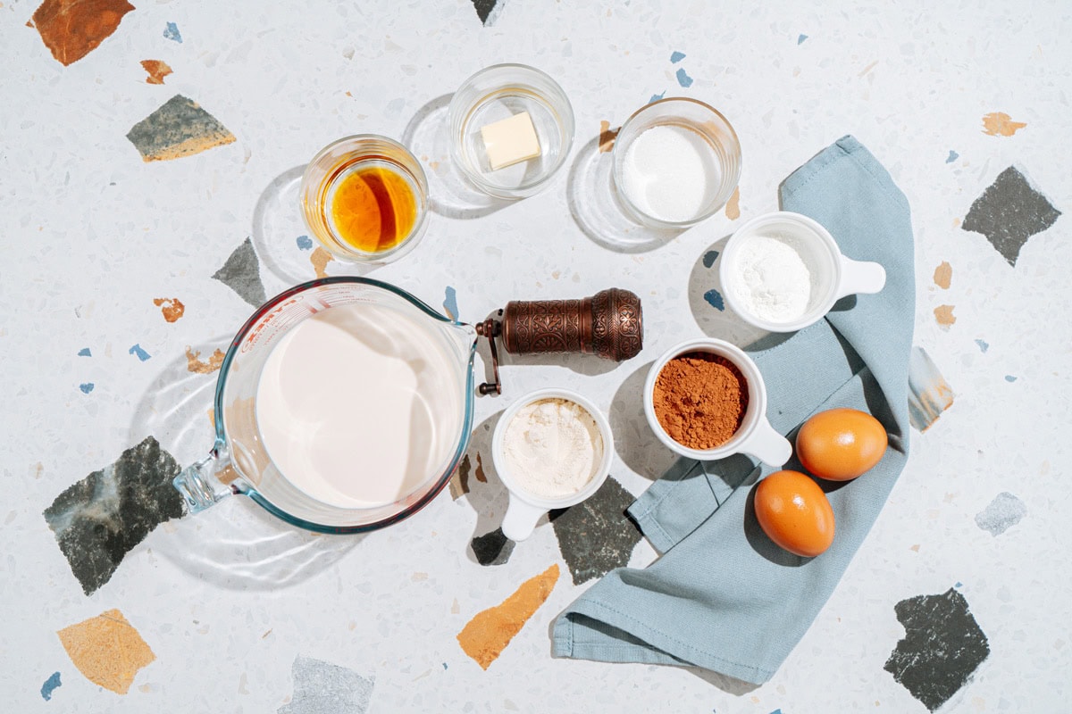 Chocolate protein pudding ingredients like protein powder, cacao powder, cornstarch, sugar, eggs, milk, butter | Hurry The Food Up