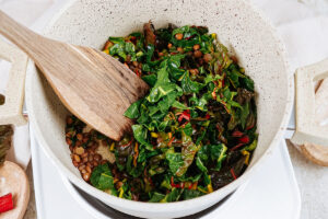 Mixing the ingredients for lentil chard side in the big bowl | Hurry The Food Up