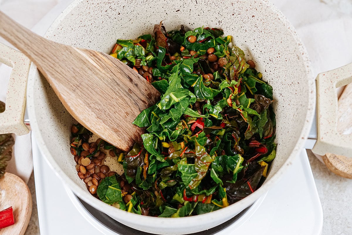 Mixing the ingredients for lentil chard side in the big bowl | Hurry The Food Up