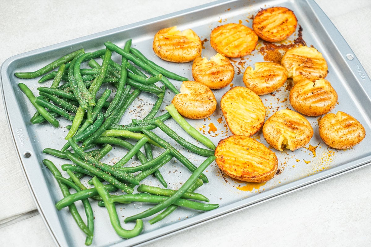 The process of laying the whole green beans and seasoning with lemon juice on a baking sheet | Hurry The Food Up