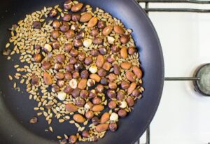 Nuts and seeds being dry fried in a small skillet | Hurry The Food Up