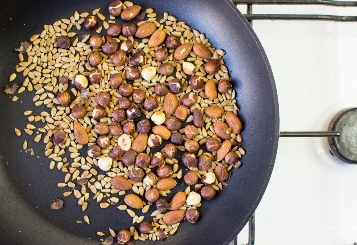 Nuts and seeds being dry fried in a small skillet | Hurry The Food Up