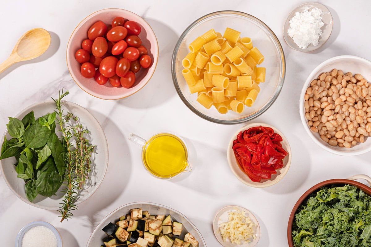 The eggplant tomato pasta ingredients like cherry tomato, eggplant, pasta, olive oil, beans, greens, garlic, bell peppers, salt, cornstarch, wooden spoon | Hurry The Food Up