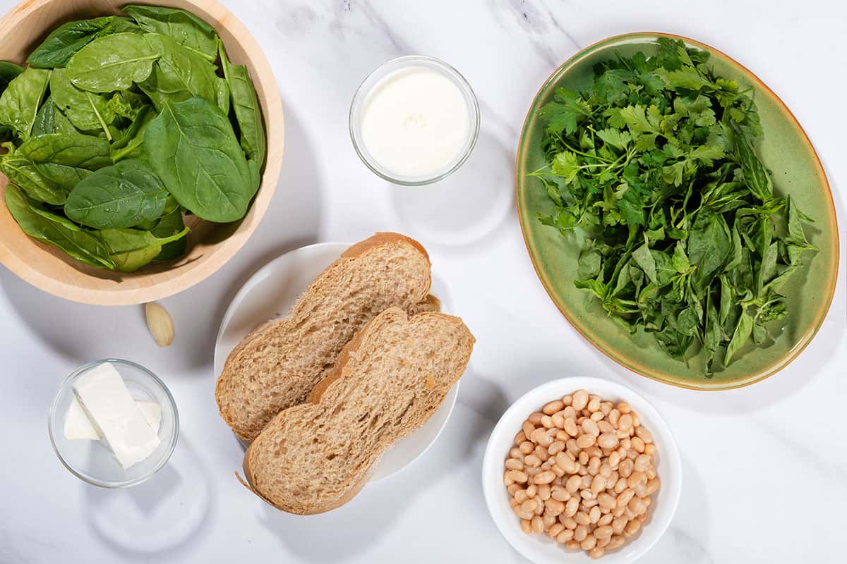 Ingredients laid out including spinach, parsley, white beans, oat milk, feta, bread slices | Hurry The Food Up
