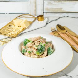 A bowl of mac and cheese on a marble table with wooden backdrop | Hurry The Food Up