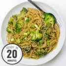 A white plate topped with Hoisin Ginger Noodles, featuring broccoli, green onions, and sesame seeds, with a fork resting on the side with a timestamp in the left corner.