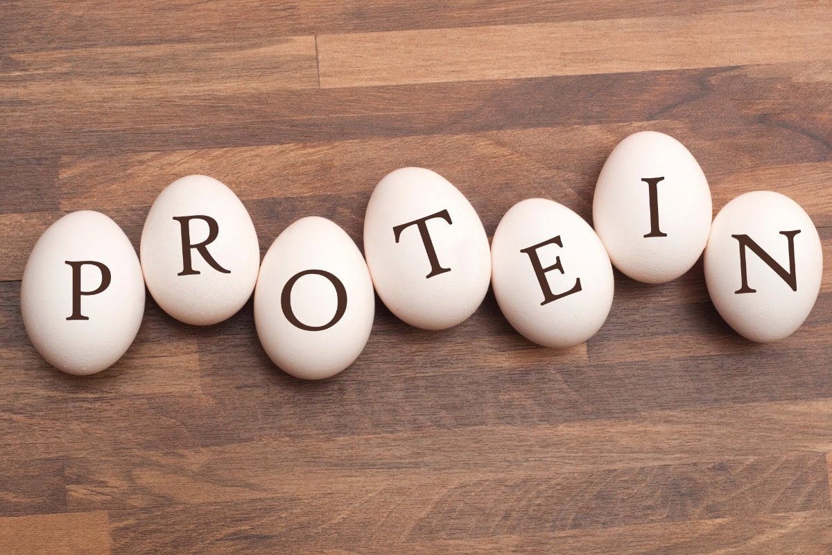 Some eggs with the sign "Protein" lie on the wooden surface | Hurry The Food Up