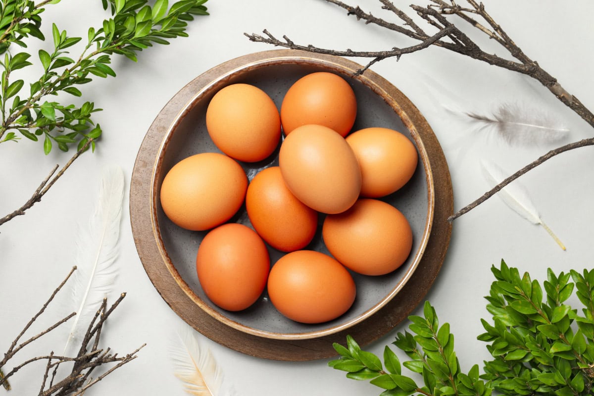 A black bowl with some eggs is on the light surface, surruonded by fresh braches | Hurry The Food Up