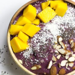 An acai bowl topped with coconut, chia, almonds, mango | Hurry The Food Up