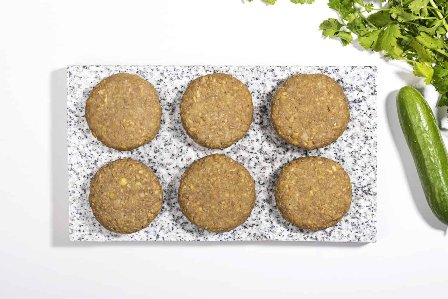Six lentil patties on a marble slate, ready to be fried | Hurry The Food Up