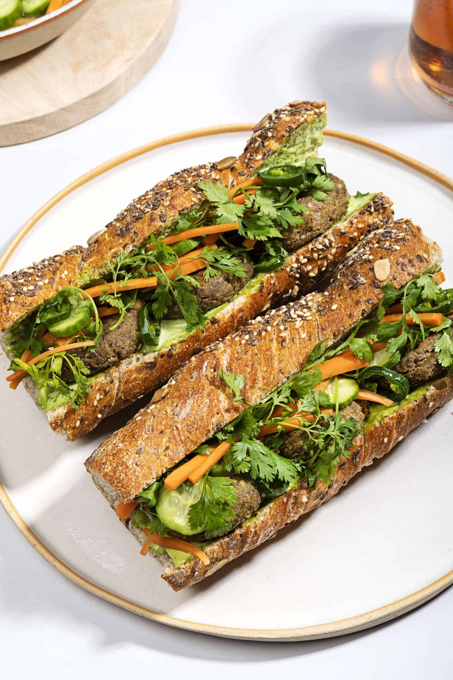 Two lentil banh-mi sandwiches on a plate, filled with lentil patties and vegetables | Hurry The Food Up