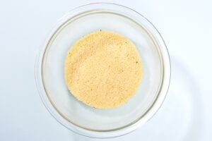 A bowl of uncooked couscous on a plain surface | Hurry The Food Up