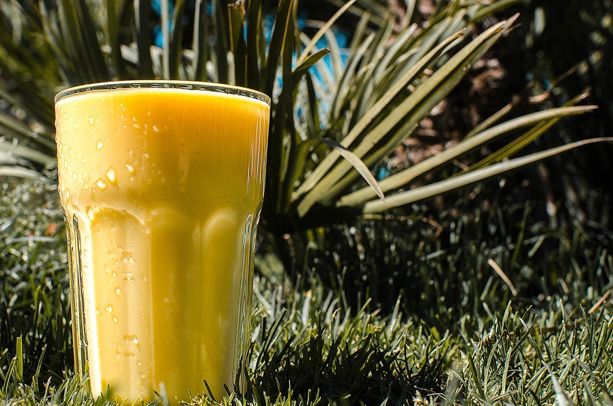 Mango Lassi is in the glass that is on the grass | Hurry The Food Up