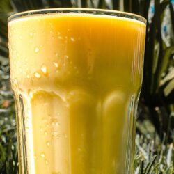 Mango Lassi is in the glass that is on the grass | Hurry The Food Up