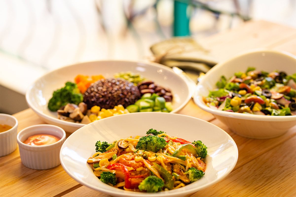 Three meals in bowls and two ramekins with sauce on a table | Hurry The Food Up
