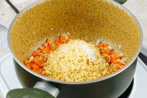 The process of adding millet to the almost well-roasting veggies into the pot | Hurry The Food Up