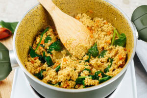 The process of adding spinach to the millet and veggies in the pot | Hurry The Food Up