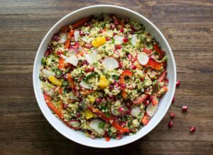 A big bowl of moroccan couscous salad is on a wooden surface | Hurry The Food Up