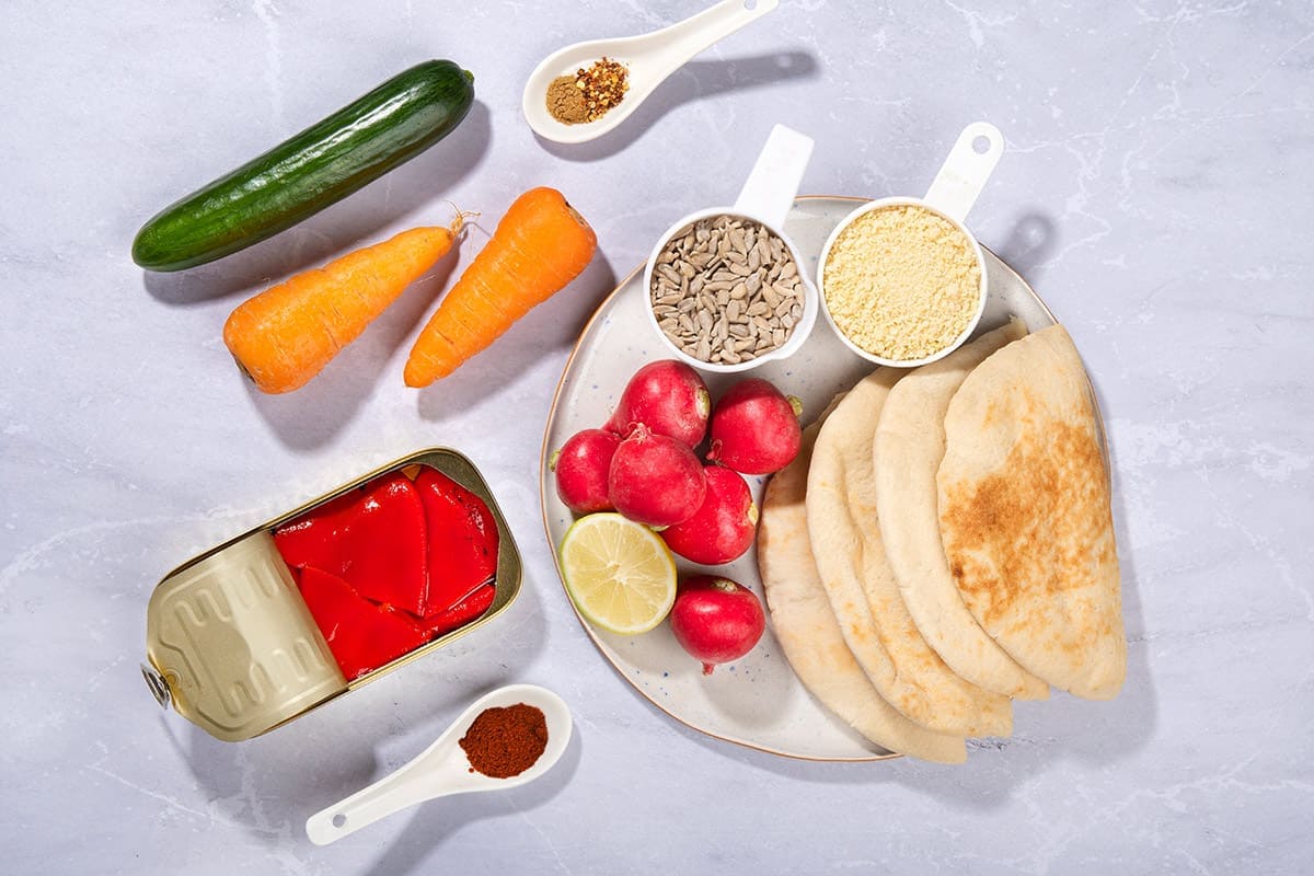Cucumber, carrots, roasted bell peppers, roasted sunflower seeds, panko, cumin, lemon juice, sugar, paprika, chili flakes and other ingredients on a marble surface | Hurry The Food Up