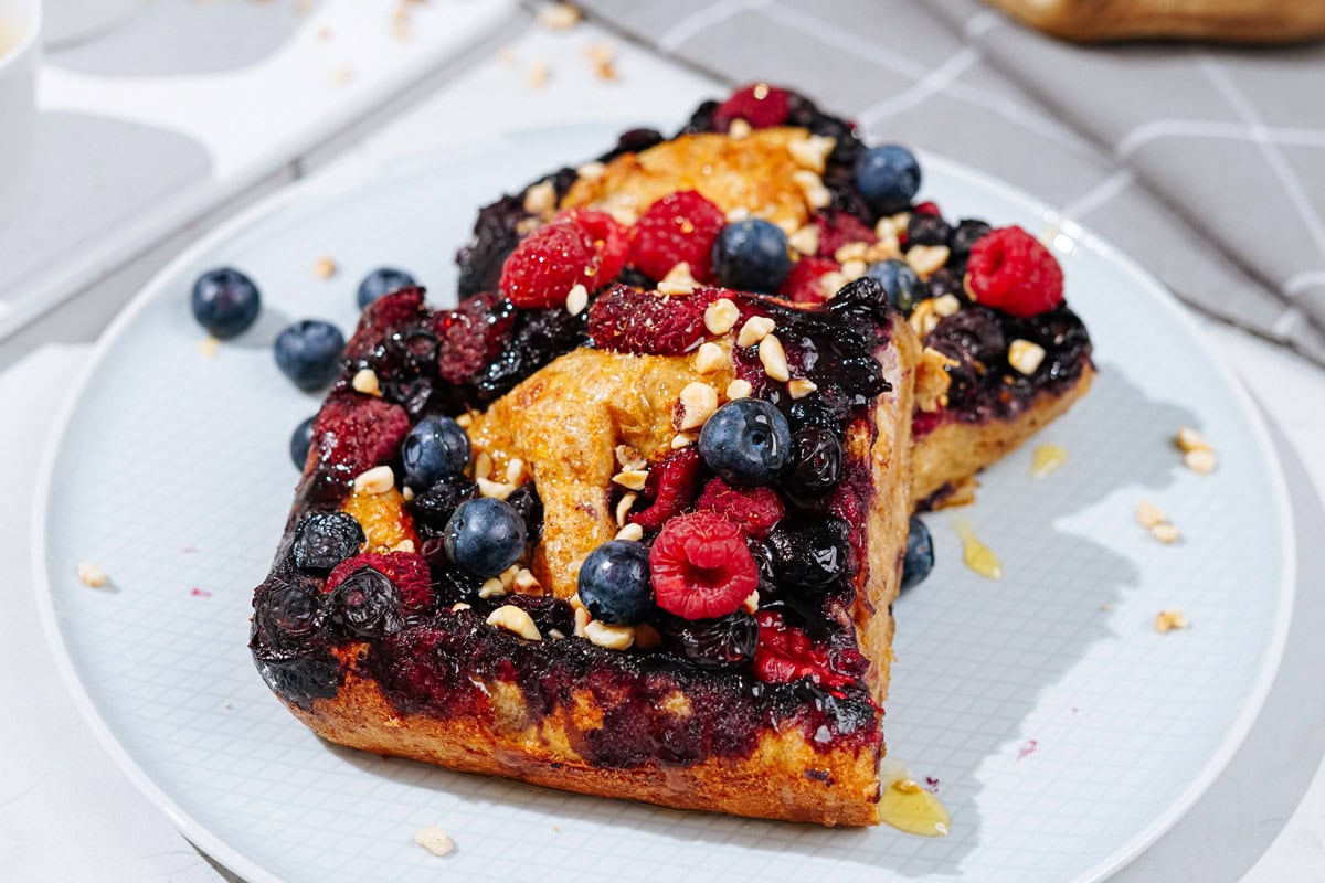 A white plate with French toast is on a light surface | Hurry The Food Up