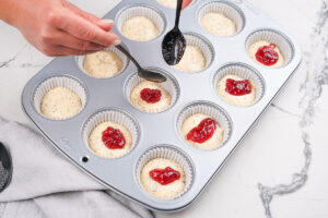 The process of pouring the batter and adding jam into the muffin cups | Hurry The Food Up