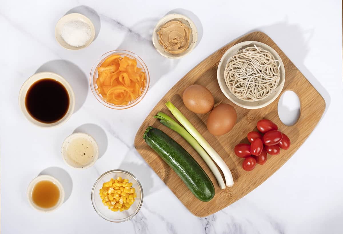 Ingredients for a noodle salad including noodles, eggs, tomatoes, carrots, zucchini, soy sauce, corn. | Hurry The Food Up