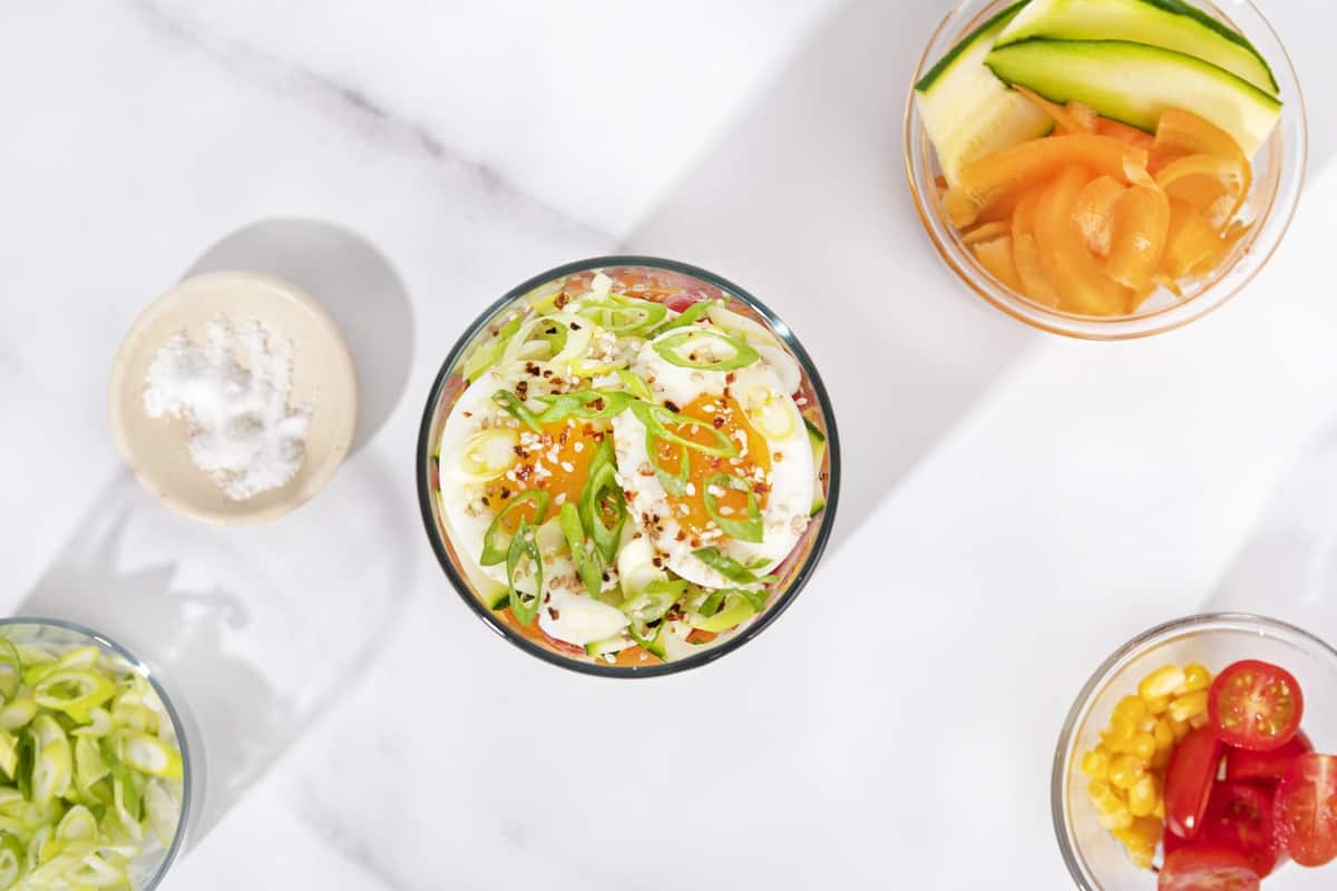 A bird’s eye view of a jar of noodle salad, and some smaller plates of prepared ingredients for the salad| Hurry The Food Up