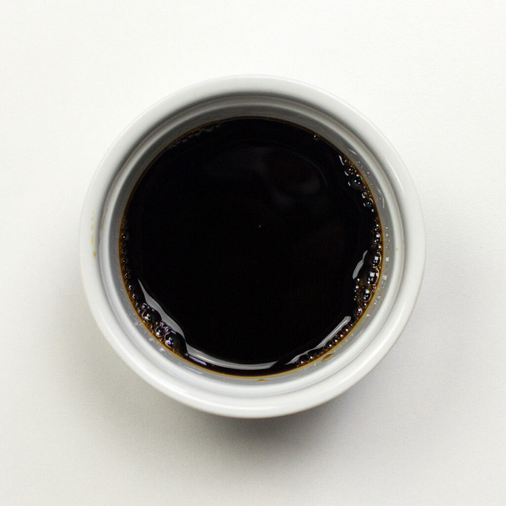 A bowl of soy sauce on white background