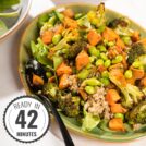 On a cream table is a sweet potato and broccoli salad on a large oval platter with a serving spoon with a time stamp in the bottom left hand corner | Hurry The Food Up